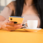 Comment changer votre vie grâce à la voyance par téléphone ? young woman drinking coffee and holding a phone